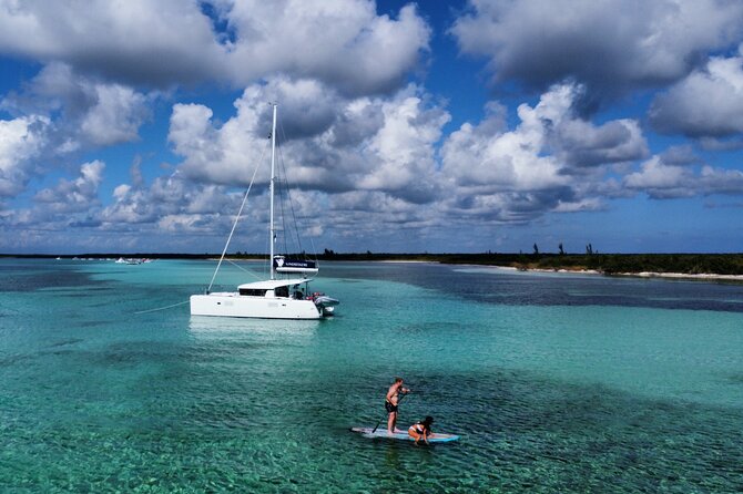 A catamaran anchored over the shallow turquoise water off Cozumel
